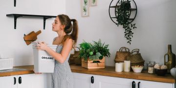 Frau mit Mülleimer