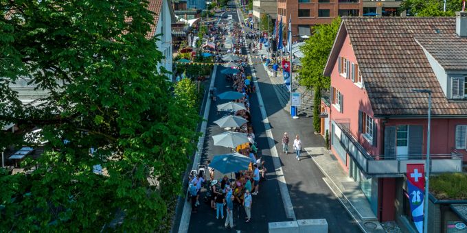 Die offizielle Einweihung der Chamerstrasse. Menschen feiern auf der Strasse