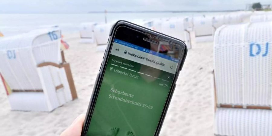 Abstandsregeln gelten auch am Strand. Der «Strandticker» via Smartphone hilft, sie einzuhalten. Foto: Carsten Rehder/dpa