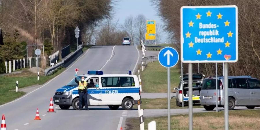 Polizisten stehen an der Bundesstrasse 512 in der Nähe von Neuhaus am Inn an einer Kontrollstelle an der Grenze zu Österreich. Foto: Sven Hoppe/dpa