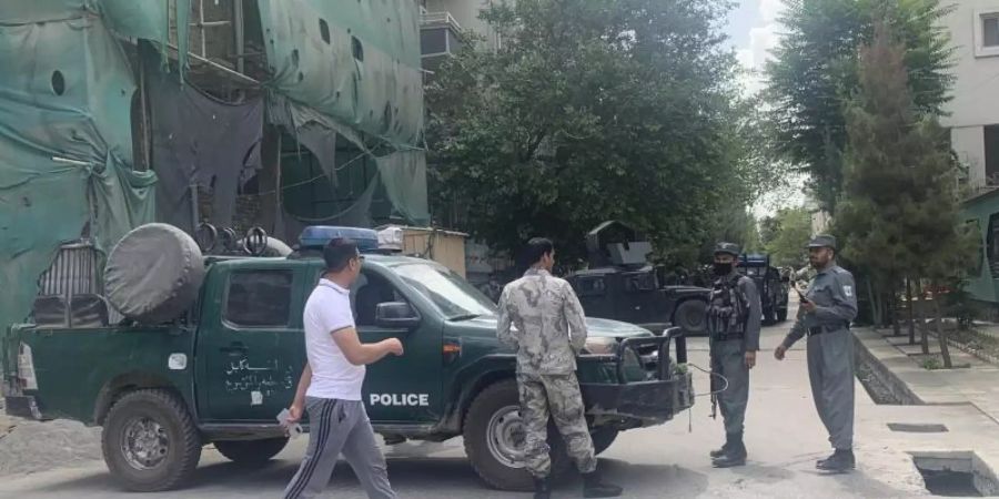 Polizisten sperren eine Strasse in der Nähe des Anschlagsorts in Kabul ab. Foto: Rahmat Gul/AP/dpa