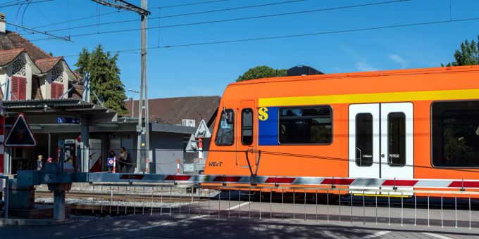 Bahnübergang beim Bahnhof Jegenstorf mit einfahrendem RBS Zug. Jegenstorf