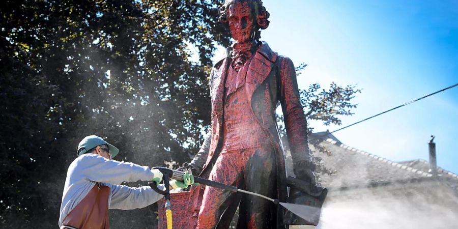 Ein Angestellter reinigte am Montagmorgen die Statue des umstrittenen Händlers David de Pury von der roten Farbe. De Pury lebte im 18. Jahrhundert.