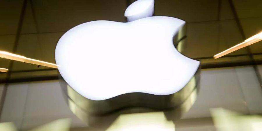 Das Apple-Logo leuchtet an der Fassade des Apple-Store in München. Die EU-Kommission hat gegen den US-Konzern zwei Kartellverfahren gestartet. Foto: picture alliance / Peter Kneffel/dpa