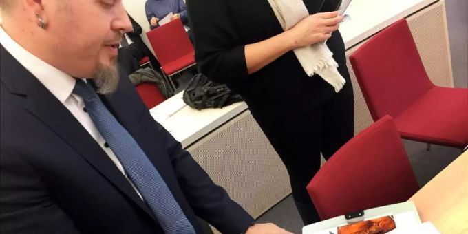 Polizeioberkommissar Jürgen Prichta hält bei der Verhandlung am Bayerischen Verwaltungsgerichthof die Entwürfe für sein geplantes Tattoo in den Händen. Foto: Britta Schultejans/dpa