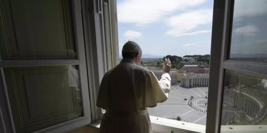 Papst Franziskus erteilt aus dem Fenster seinen Segen mit Blick auf den Petersplatz, der aufgrund der Anti-Corona-Massnahmen menschenleer ist. Foto: Uncredited/Vatican News/dpa