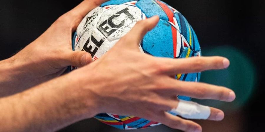 Ein Handballer hält den Spielball in den Händen. Foto: Robert Michael/dpa/Symbolbild