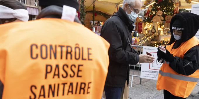 Eine Frau kontrolliert den Gesundheitspass in Frankreich. Frankreich