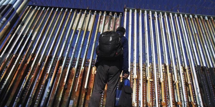 Ein Mann steht an der US-mexikanischen Grenze in Tijuana. Foto: Marco Ugarte/AP/dpa