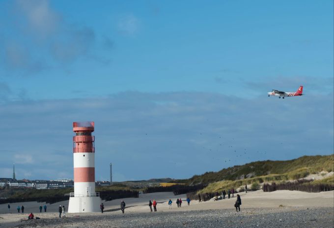 Die Insel Helgoland ist nun mit einem weiteren Festland-Flugplatz verbunden. Leuchtturm Flugzeug Strand Dünen