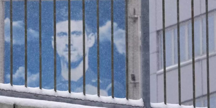 Ein Plakat mit dem Konterfei des serbischen Tennisspielers Novak Djokovic hängt an einem Gebäude. Foto: Darko Vojinovic/AP/dpa