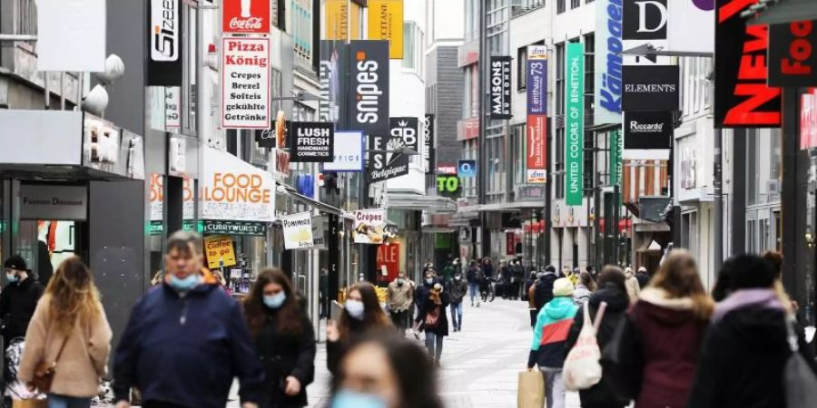 Menschen gehen durch die Fussgängerzone Hohe Strasse in Köln. Foto: Oliver Berg/dpa