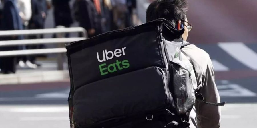 Ein Mitarbeiter des Essenslieferdienstes Uber Eats radelt mit einer Lieferung durch die Stadt. Foto: -/kyodo/dpa