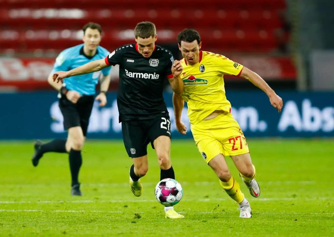 Leverkusens Florian Wirtz (l) und Freiburgs Nicolas Höfler kämpfen um den Ball. Bayer Leverkusen
