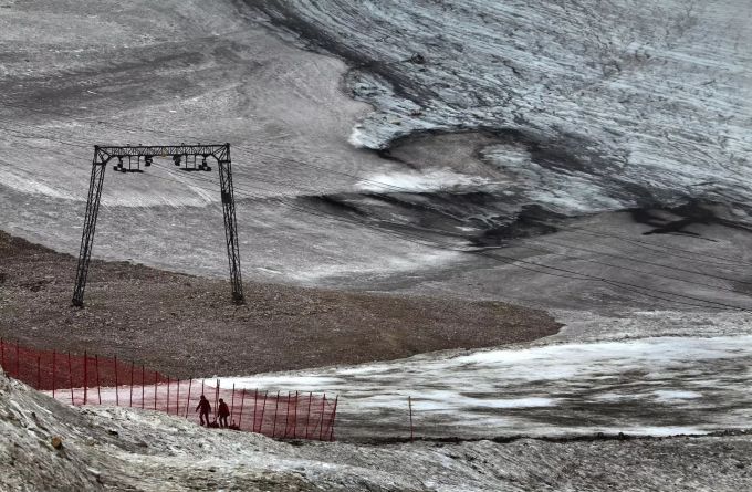 Ausflügler gehen auf Schneeresten des Schneeferner-Gletscher auf dem Zugspitzblatt einen Hang hinauf. Gletscher