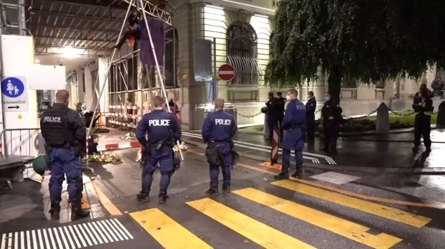 Viele Aktivisten verharren eingehüllt in einer Rettungsdecke unter einem Baugerüst in der Bundesgasse.