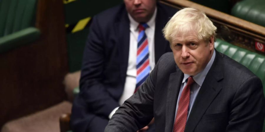 HANDOUT - Boris Johnson (r), Premierminister von Grossbritannien, gibt im britischen Unterhaus vor den Abgeordneten eine Erklärung ab. Foto: Jessica Taylor/UK Parliament/AP/dpa - ACHTUNG: Nur zur redaktionellen Verwendung und nur mit vollständiger Nennung des vorstehenden Credits