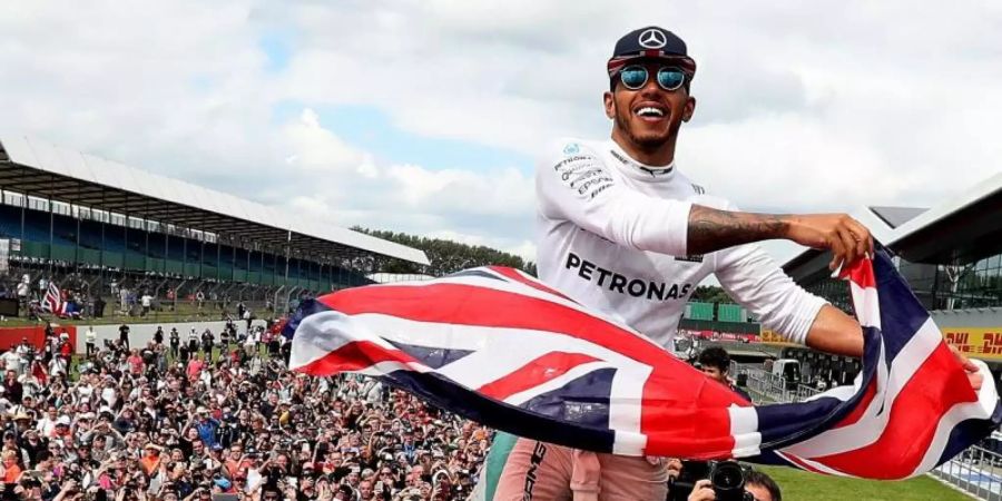 Der Mercedes-Formel-1-Pilot Lewis Hamilton feiert seinen Sieg mit dem Publikum auf dem Silverstone Circuit. Foto: David Davies/PA Wire/dpa