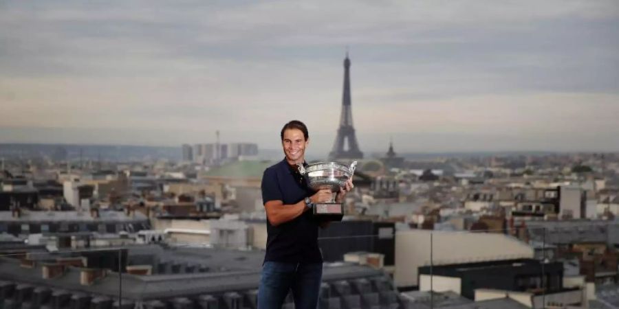 French-Open-Sieger Rafael Nadal posiert mit dem Siegerpokal vor der Kulisse von Paris auf dem Dach der Galeries Lafayette. Foto: Francois Mori/AP/dpa