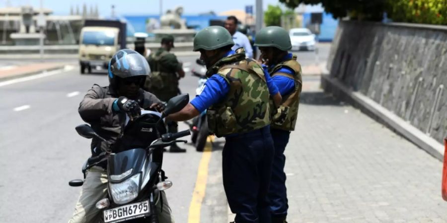 Soldaten stoppen ein Motorrad an Kontrollpunkt in Colombo