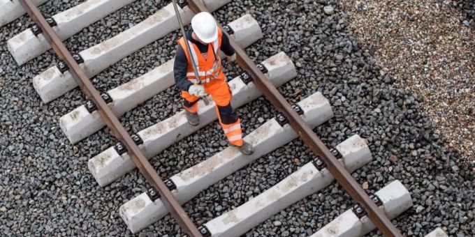 Ein Arbeiter geht über eine noch nicht fertige Gleisanlage der Bahn. Foto: Lukas Schulze/Illustration Ein Arbeiter geht über eine noch nicht fertige Gleisanlage der Bahn. Foto: Lukas Schulze/Illustration