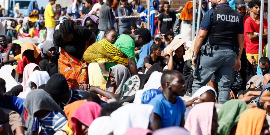 Migranten warten darauf, von der Insel Lampedusa auf das Festland gebracht zu werden.