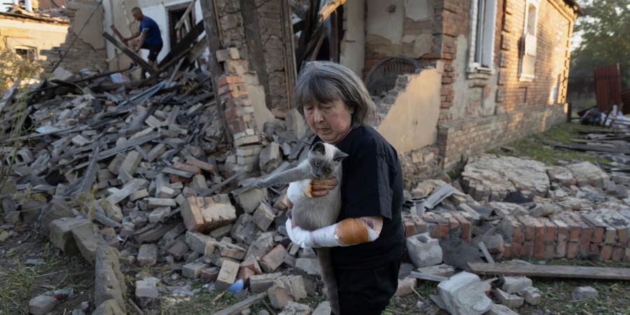 Eine Anwohnerin steht vor ihrem Haus, das durch einen Raketenangriff in Kostjantyniwka in der Region Donezk beschädigt wurde.