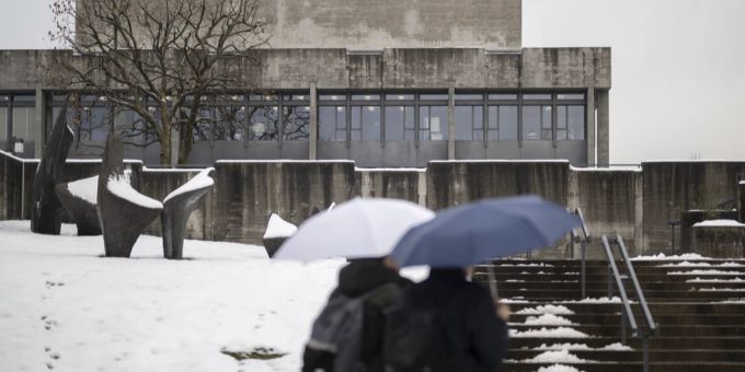 Zwei Personen mit Regenschirm vor der HSG in St. Gallen. HSG Plagiatsaffäre