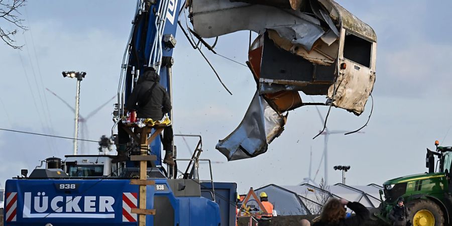 Ein Bagger transportiert bei der Räumung von Lützerath das Wrack eines Wohnwagens. Foto: Federico Gambarini/dpa