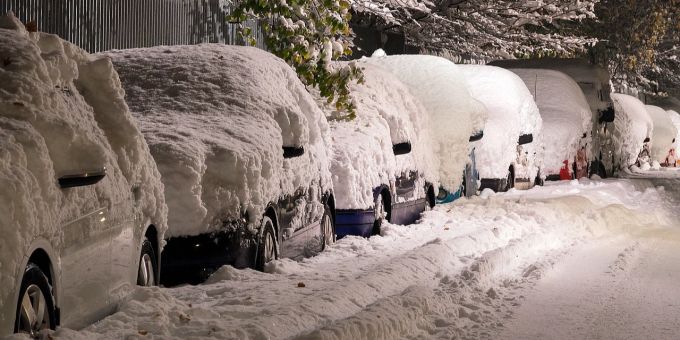 Bei Schnee muss beim Parkieren besondere Rücksicht genommen werden: auch auf ein allfälliges Vorbeikommen des Winterdienstes. Autos Strassenrand Parkieren Schnee Winter dunkel