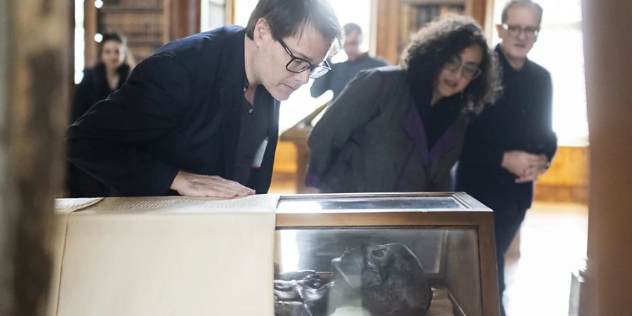 Der Theaterregisseur Milo Rau mit der in der St. Galler Stiftsbibliothek ausgestellten Mumie Schepenese. (Archivbild)