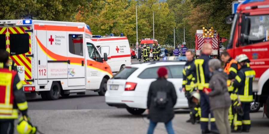 Einsatzkräfte der Feuerwehr und des Roten Kreuzes stehen nach einem Gasaustritt vor der Schule in Idstein