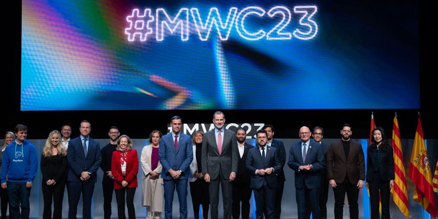 Der spanische König Felipe VI. (M) gemeinsam mit weiteren Teilnehmern bei der Eröffnung des Mobile World Congress 2023 in Barcelona.