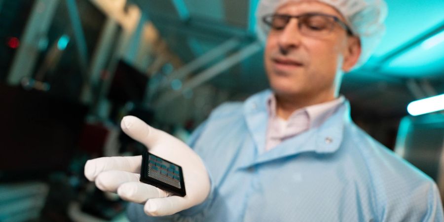 Harald Schenk, Leiter des Fraunhofer Instituts für Photonische Mikrosysteme und Professor für Mikro- und Nanosysteme, hält Sensoren in der Hand.