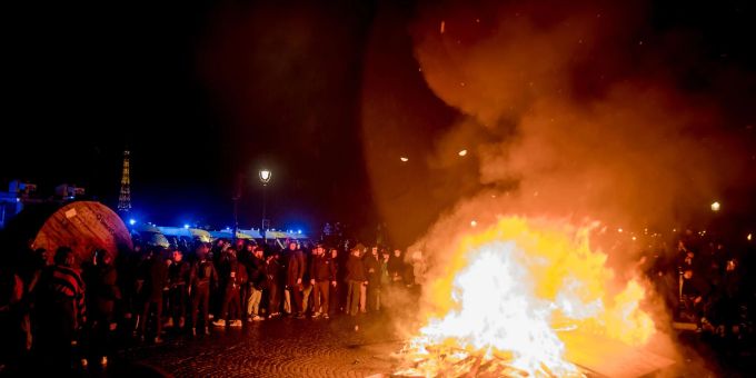 Demonstranten stehen neben einer brennenden Barrikade auf dem Place de la Concorde in Paris. Demonstranten stehen neben einer brennenden Barrikade auf dem Place de la Concorde in Paris.