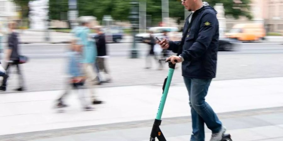 Auf zwei winzigen Rädern im Innenstadtverkehr, die Augen fest aufs Handy geheftet: Ein Tourist fährt durch Berlin-Mitte. Foto: Bernd von Jutrczenka