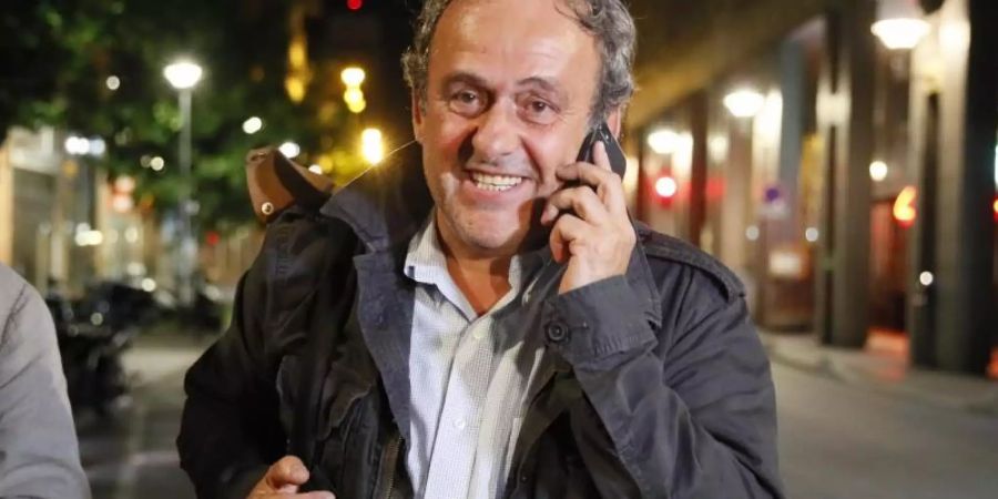 Michel Platini telefoniert nach seiner Entlassung aus dem Gewahrsam der Polizei. Foto: Francois Mori/AP