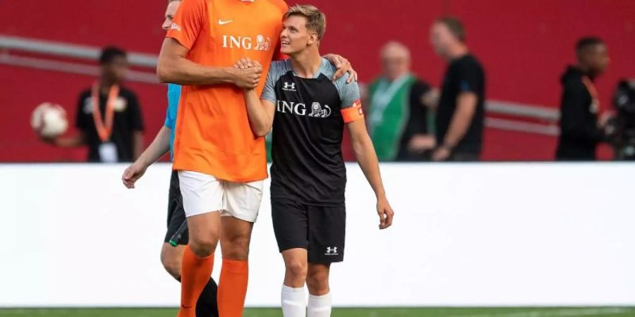 Dirk Nowitzki (l) und Mick Schumacher klatschen sich während der Partie ab. Foto: Marius Becker