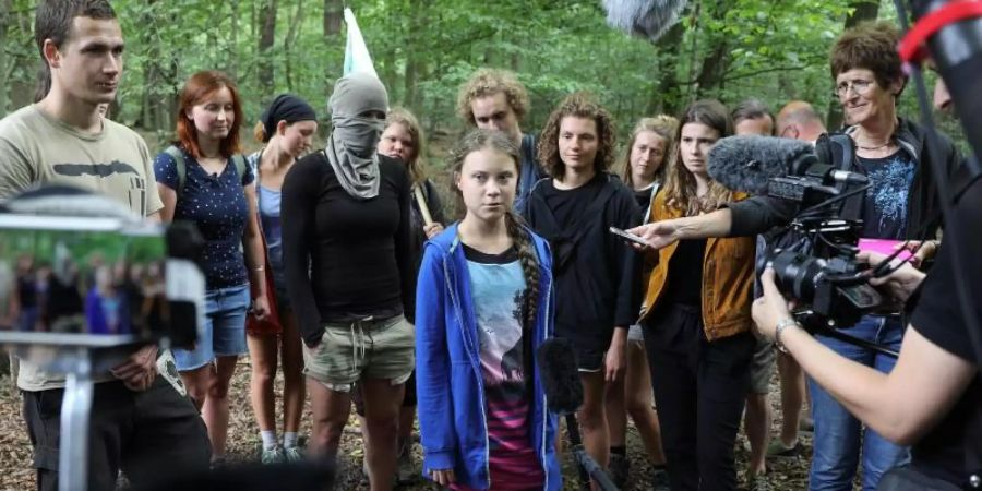 Greta Thunberg (M), Klimaschutzaktivistin, steht mit Aktivisten im Hambacher Forst. Foto: Oliver Berg