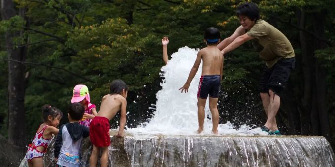 Japaner suchen wegen der Sommerhitze Abkühlung in einem Brunnen. Japan Sommerhitze