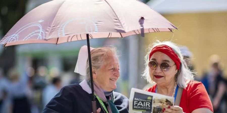 Ein probates Mittel: Der Regenschirm als Sonnenschutz. Foto: Guido Kirchner