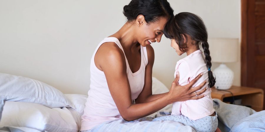 Mutter mit Tochter auf dem Bett