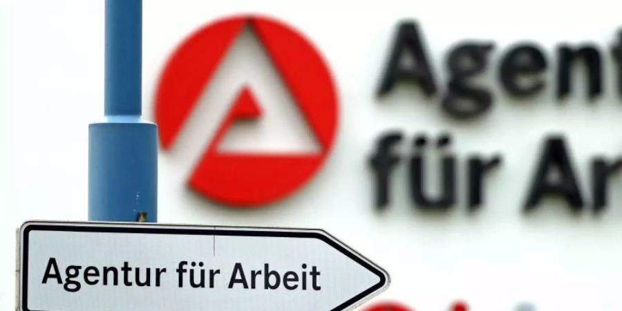 Ein Schild weist den Weg zur Agentur für Arbeit. Foto: Jan Woitas/zb/dpa