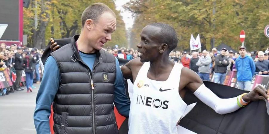 Radstar Chris Froome beglückwünscht Marathon-Weltrekordhalter Eliud Kipchoge in Wien direkt nach dem Zieleinlauf. Foto: Herbert Neubauer/APA/dpa