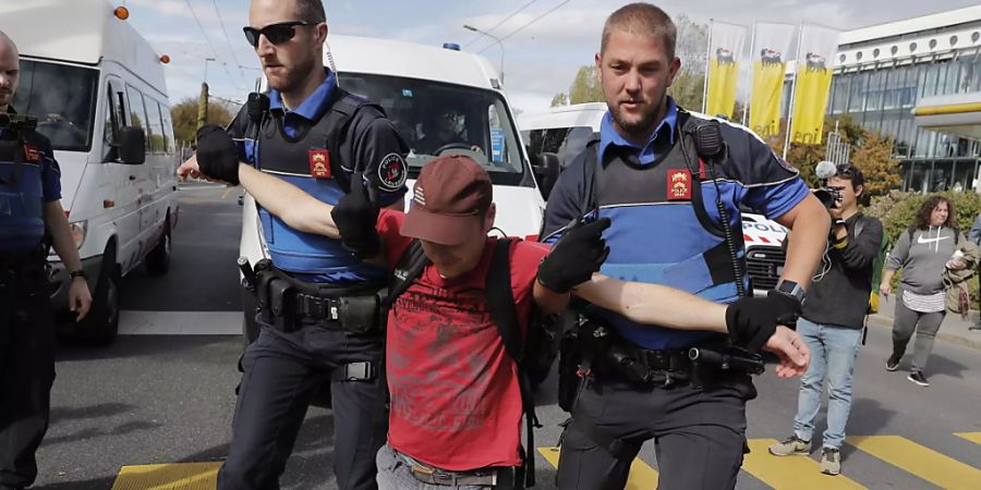 Ein Teilnehmer der Klimademonstration in Lausanne wird von der Polizei weggetragen.