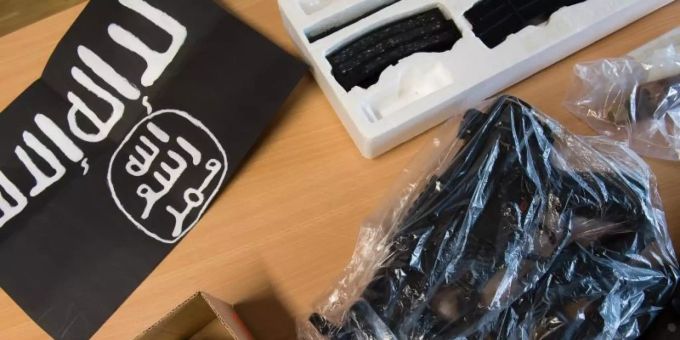 Beschlagnahmte Gegenstände liegen während einer Pressekonferenz der Polizei neben einer IS-Flagge. Foto: Swen Pförtner/dpa Beschlagnahmte Gegenstände liegen während einer Pressekonferenz der Polizei neben einer IS-Flagge. Foto: Swen Pförtner/dpa