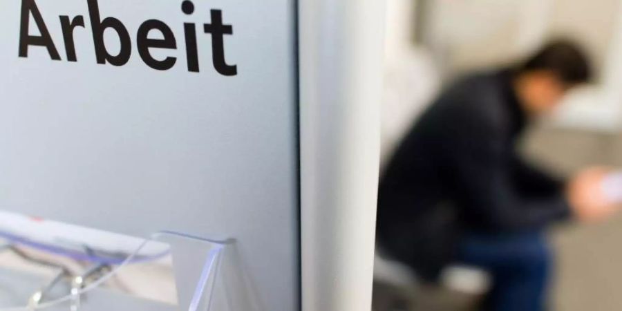 Ein Mann sitzt in der Bundesagentur für Arbeit. Foto: Julian Stratenschulte/dpa