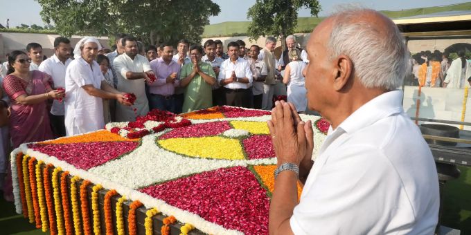 Menschen feiern am Denkmal von Mahatma Gandhi in Neu-Delhi. Mahatma Gandhi