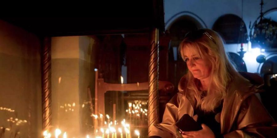 Weihnachten in Bethlehem: Eine Besucherin zündet eine Kerze in der Geburtskirche an. Foto: Majdi Mohammed/AP/dpa