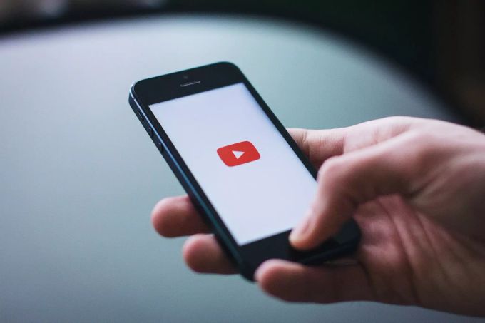 Eine Person öffnet YouTube auf einem Smartphone. youtube